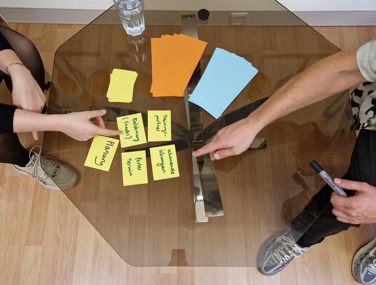 Coach und Klientin arbeiten am Tisch mit Moderationskarten