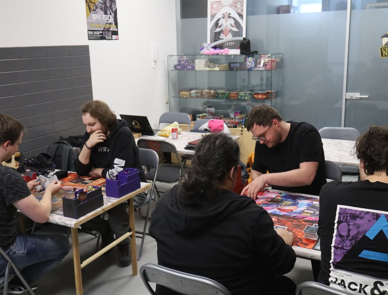People playing card games inside the Crow's Nest TCG shop.