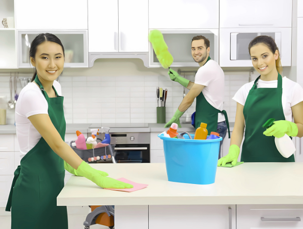 a couple of people in aprons cleaning a counter