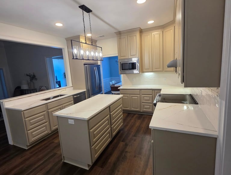 Modern kitchen featuring beige cabinets, quartz countertops, a central island, and dark wood flooring.