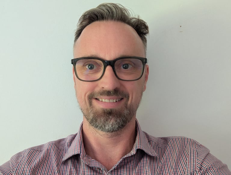 a handsome man with glasses and a beard