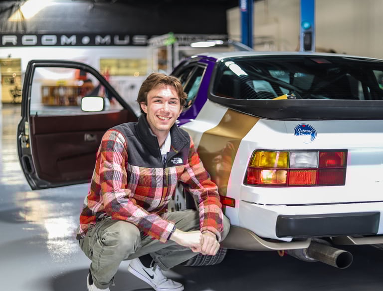 Luke Gilmore next to a Porsche 944.