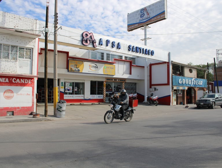 a motorcycle rider riding down a street in front of a building