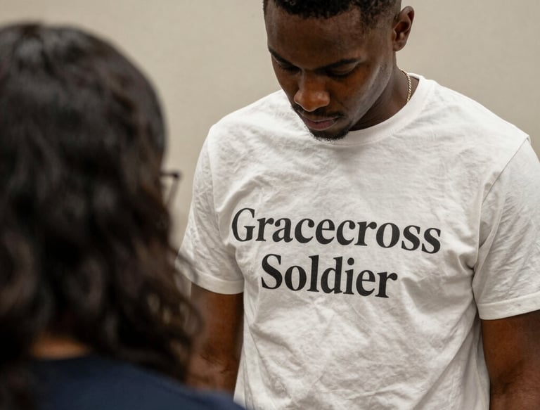 A modern church building surrounded by a landscaped garden and path. The architecture includes brick walls, a large entrance with a prominent roof, and a cross visible on top. The sky is partly cloudy with a sunset in the background creating a warm glow.