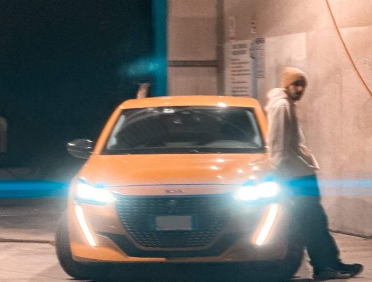 Ragazzo accanto a Peugeot 208 accesa. Passione per le auto raccontata in un blog autentico