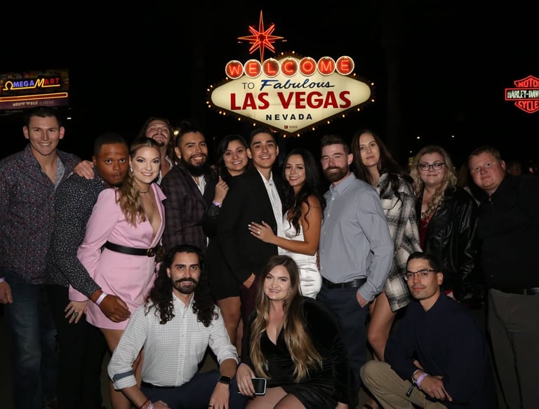Group photo in front of the Welcome to Las Vegas sign during a VIP club crawl experience.