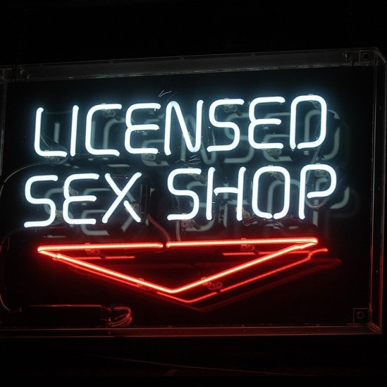 a neon sign that reads licensed sex shop