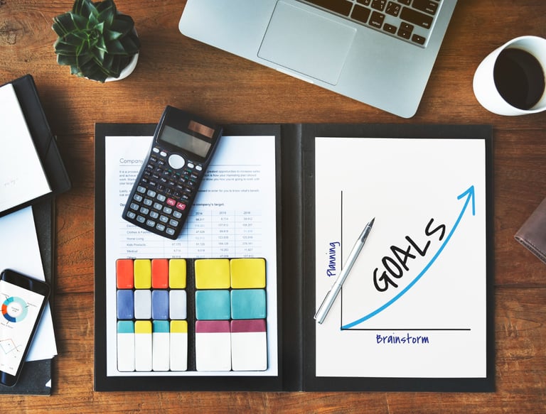 Pracovní stůl s grafy a plánem jako symbol výsledků online marketingu a strategie.