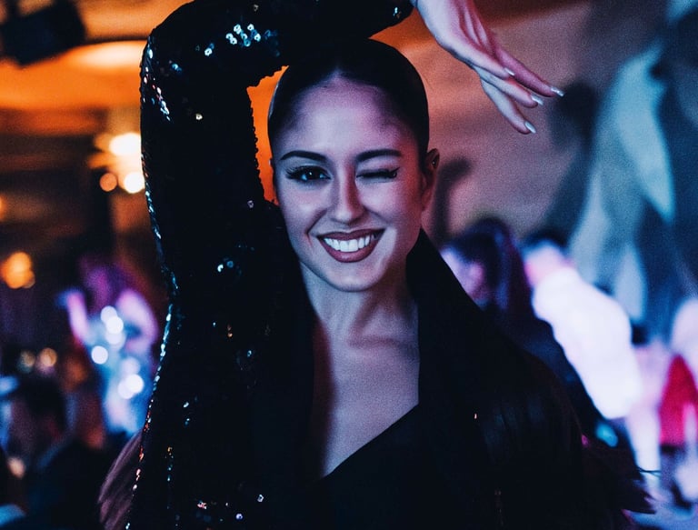 bailarina guiñando un ojo, posando en el restaurante mientras se desarrolla el show dinner