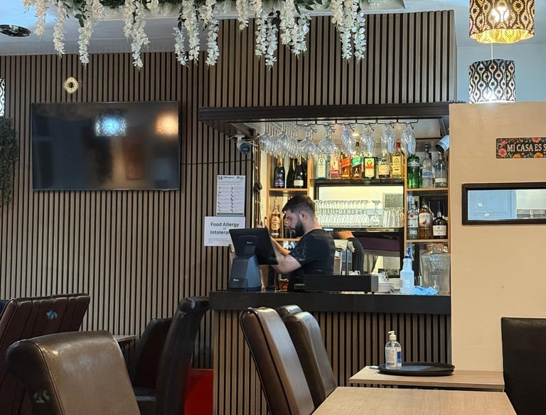 a restaurant with a bar and man  crafting a drink in a bar