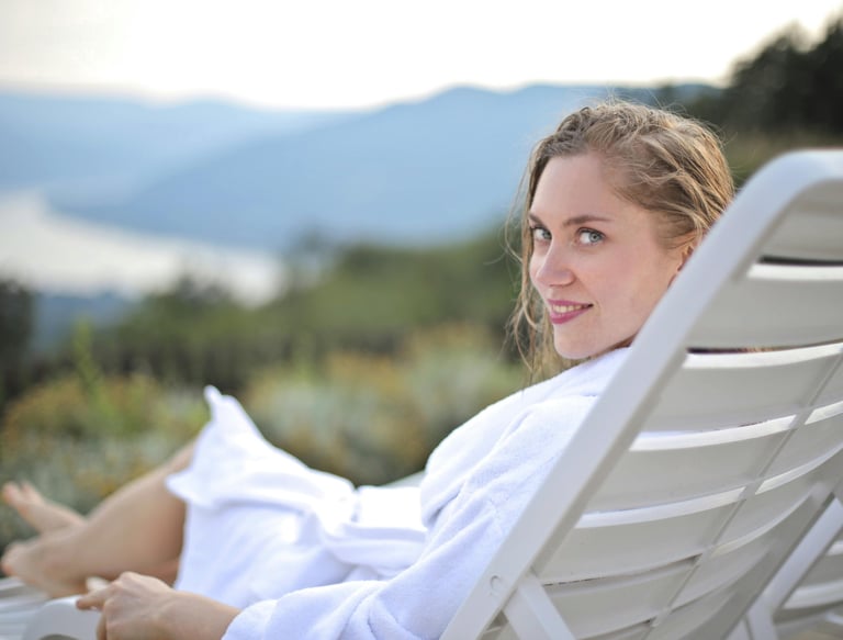 Woman relaxing on resort lounger with scenic mountain view — spa deals