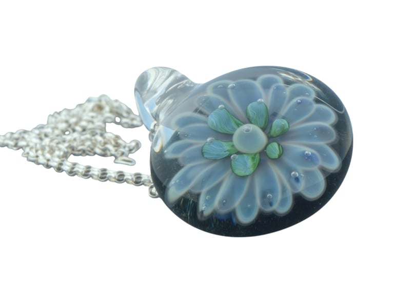 a glass pendant necklace with a flower on it