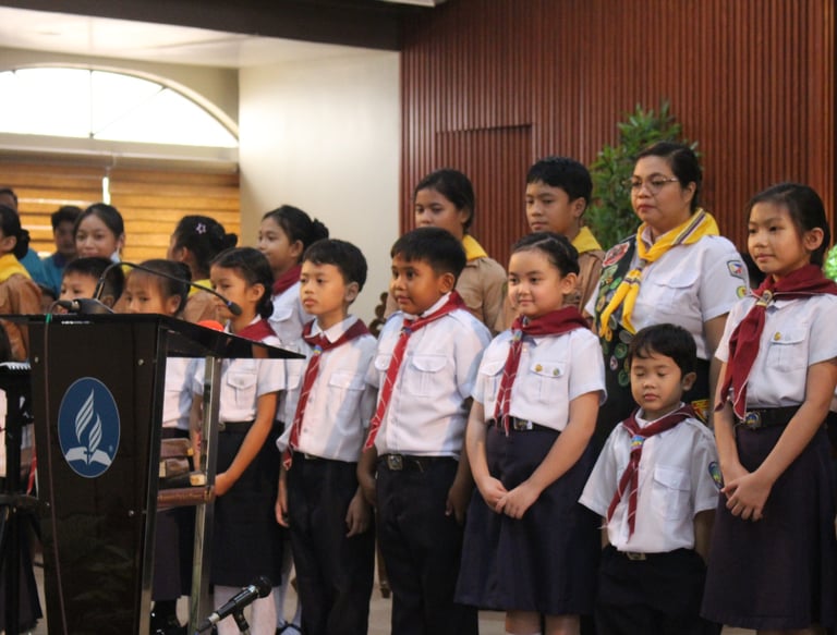 Groups of elementary students standing with scouts uniform