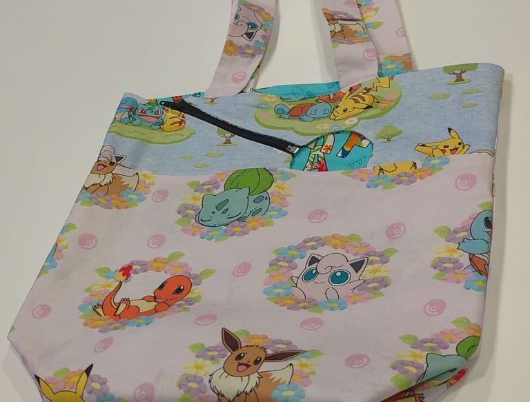aphoto of a tote with an opening made out of pokemon fabric