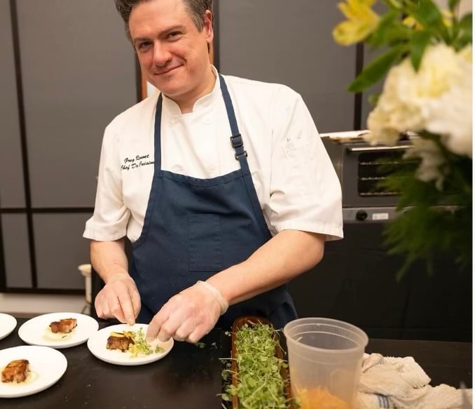 Chef Greg serving pork belly and green curry puree and pickled carrots