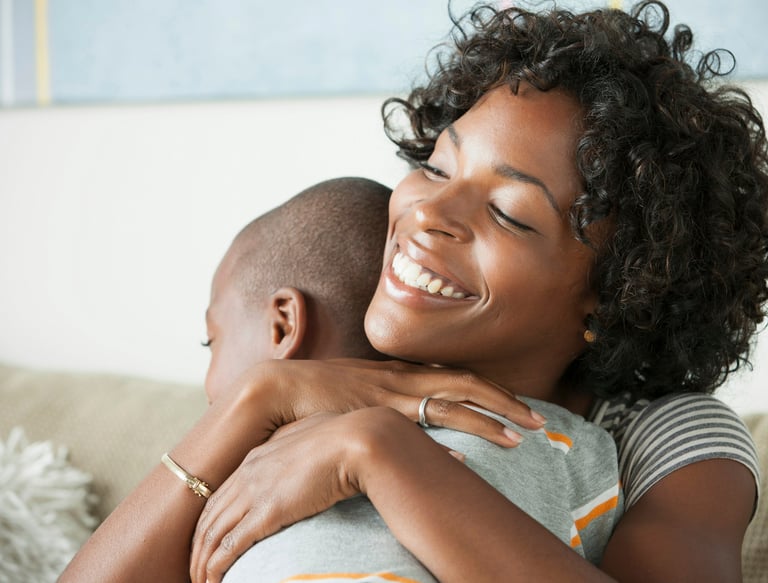 a woman is hugging her baby and smiling