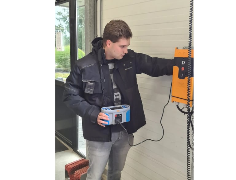 Inspecteur test elektrische laadinstallatie met meetapparatuur in industriële omgeving