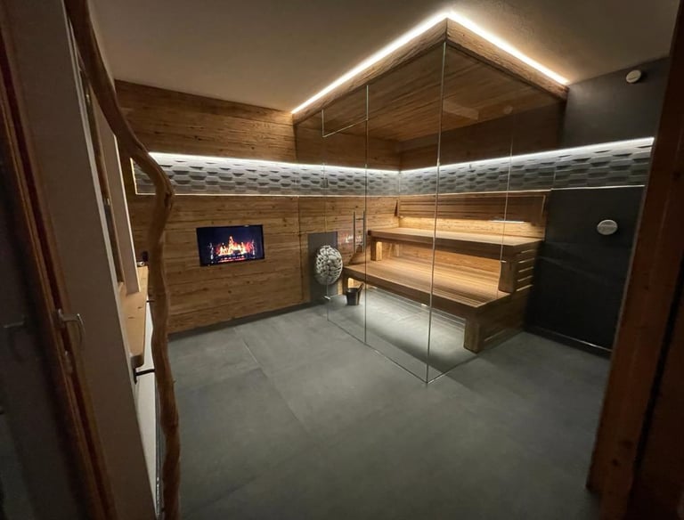 Moderne Innensauna mit Eckverglasung, ausgestattet mit rustikaler Holzverkleidung und indirekter LED-Deckenbeleuchtung