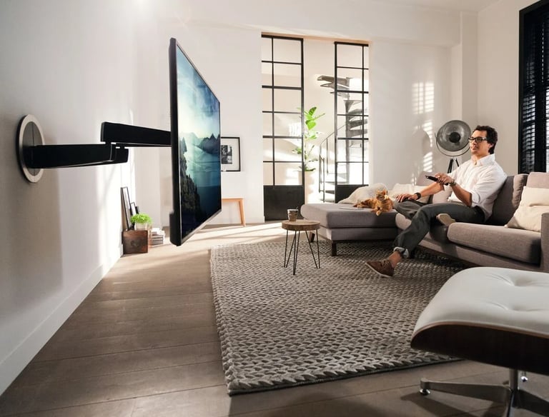 A couple enjoying a movie in a luxury London living room featuring a custom motorised TV mount
