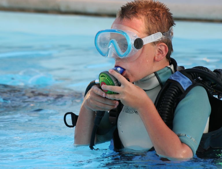 a boy in a diving suit and goggles in the water