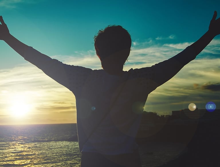 homme levant les bras face au soleil. nouveau depart grace a la therapie breve