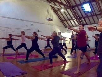 a group of people doing yoga exercises in a gym