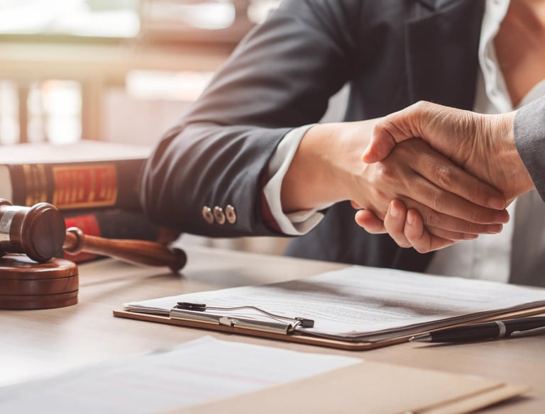 Apretón de manos en oficina legal, asesoramiento en Derecho Laboral.