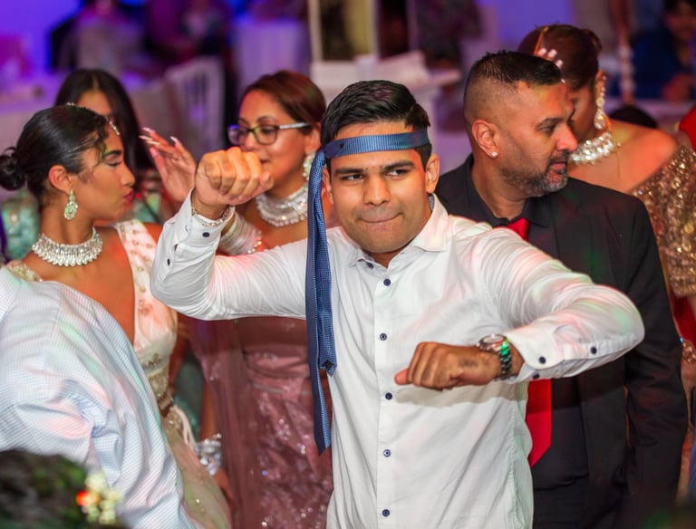 man aan het dansen met een stropdas om het hoofd