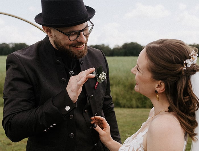 das alternative Hochzeitspaar strahlt sich nach dem Einzug an. der Bräutigam zeigt ihr, wie toll er ihren Style findet