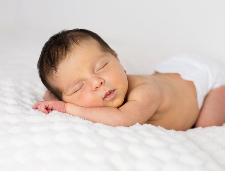 Sessió de fotos newborn a Girona amb una bebè recent nascuda dormint en estudi fotogràfic