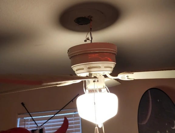 a ceiling fan with a light fixture on top of a ceiling fan