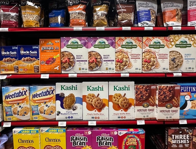 Cereal aisle at Round Hill Market featuring brands like KIND, Cascadian Farm, Kashi, Cheerios, and Lucky Charms.