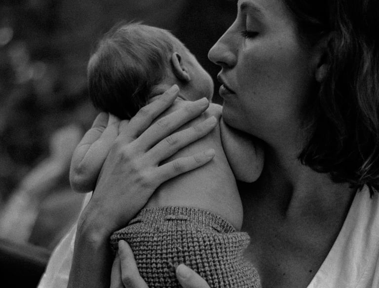 natural newborn photograph of mom holding baby looking over her shoulder