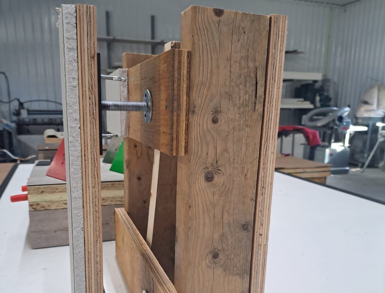 Wall assembly mock-up showing drywall and wood framing joined with metal anchor bolts for levelling demonstration