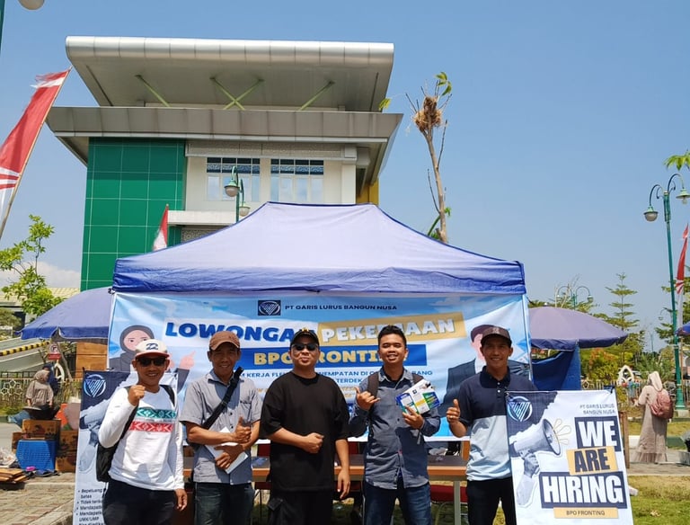 a group of people standing around a table with a sign