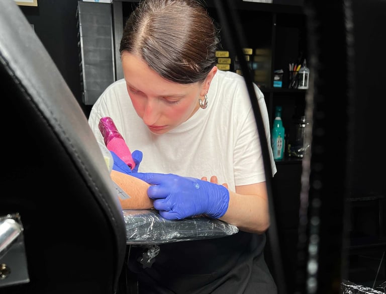 Tatuadora Sakine a fazer uma tatuagem no estúdio de tatuagens e body piercing em V