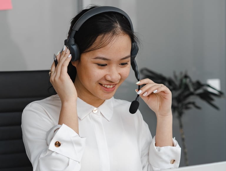 a woman in a white shirt and headphones on a laptop