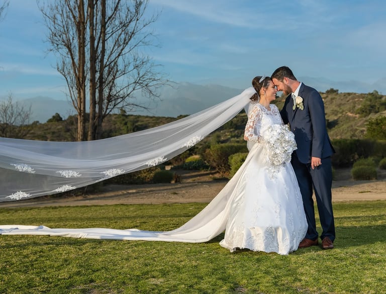a bride and groom kissing in a field