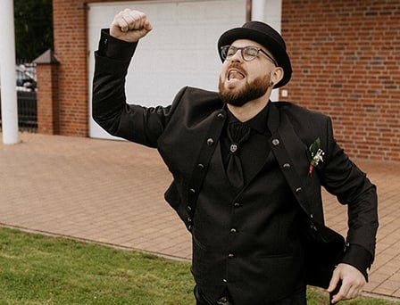 der Bräutigam im alternativen schwarzen Style feiert emotional seinen eigenen Einzug