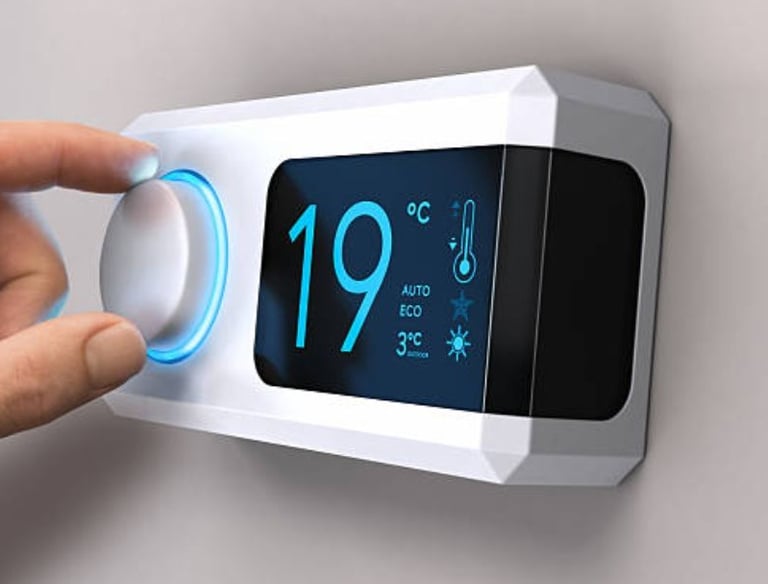 main qui règle un thermostat d'ambiance blanc et noir sur 19 degrès
