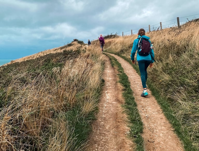 a woman in a blue jacket and a man in a blue jacket are walking up
