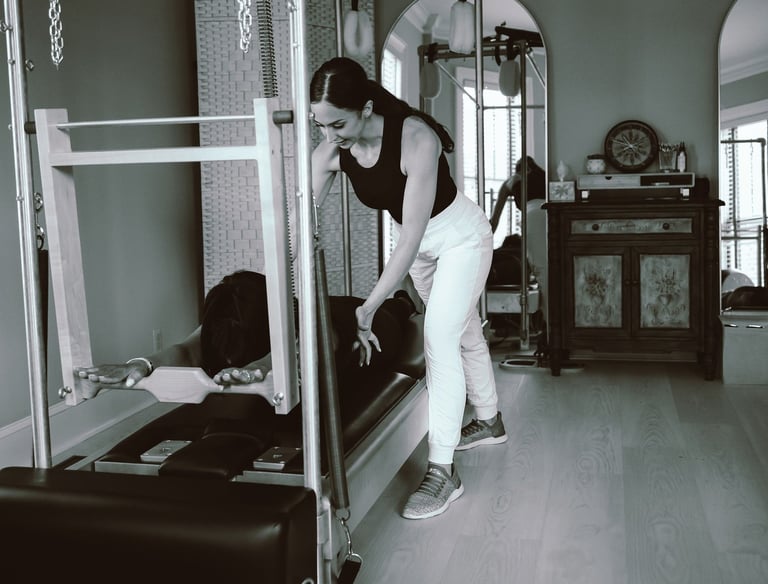 photo of 27 Pilates owner and instructor Tina Blondin giving a reformer class