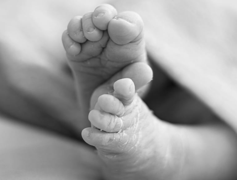 Detall dels peus d'un bebè nounat en una sessió de fotos newborn a Girona en estudi fotogràfic