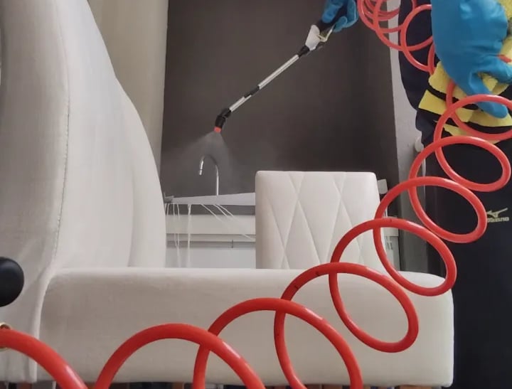 Aplicação de impermeabilizante em cadeira clara em Campinas, borrifação controlada para repelir.