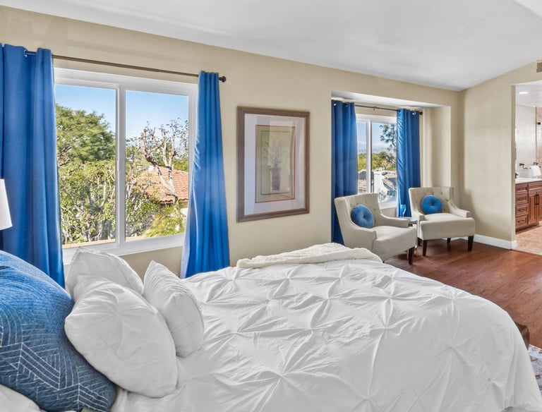 a bedroom with a bed and a large window