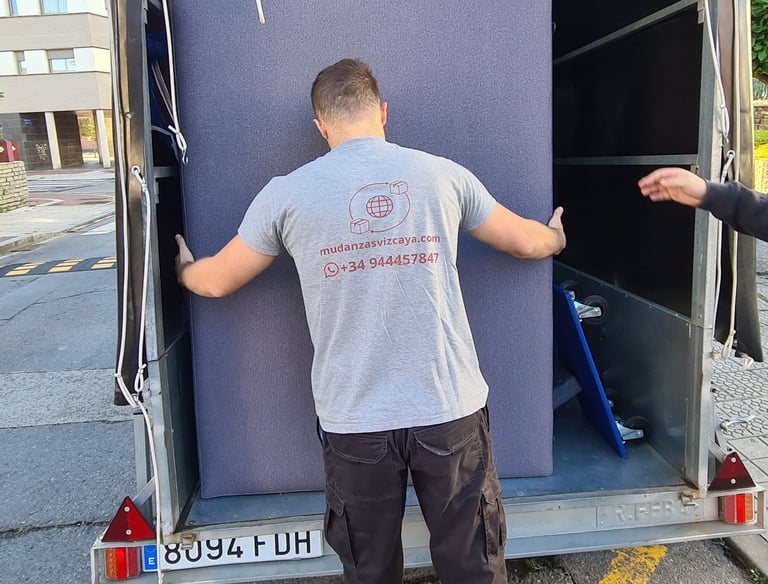 a man is moving a couch into a moving truck