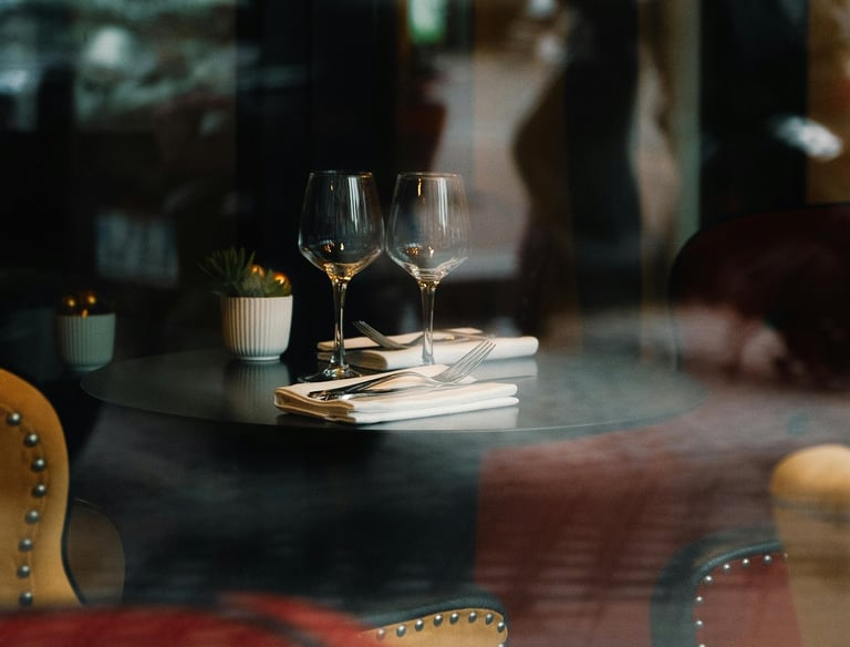 a table with a plate of food and wine glasses