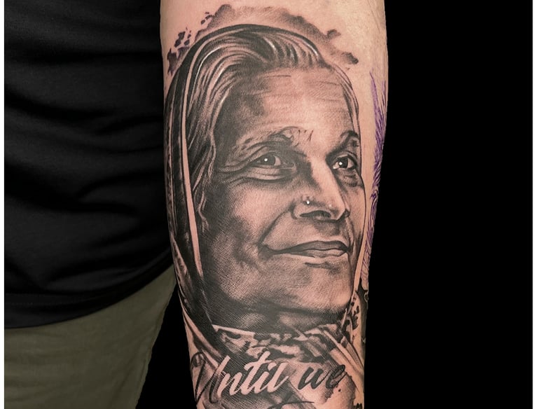 Photo of a portrait tattoo of a women on the arm