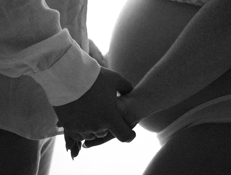 maternity photograph from the side of couple holding hands in a Littlehampton studio