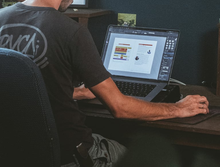 a man sitting at a desk with a laptop computer designing